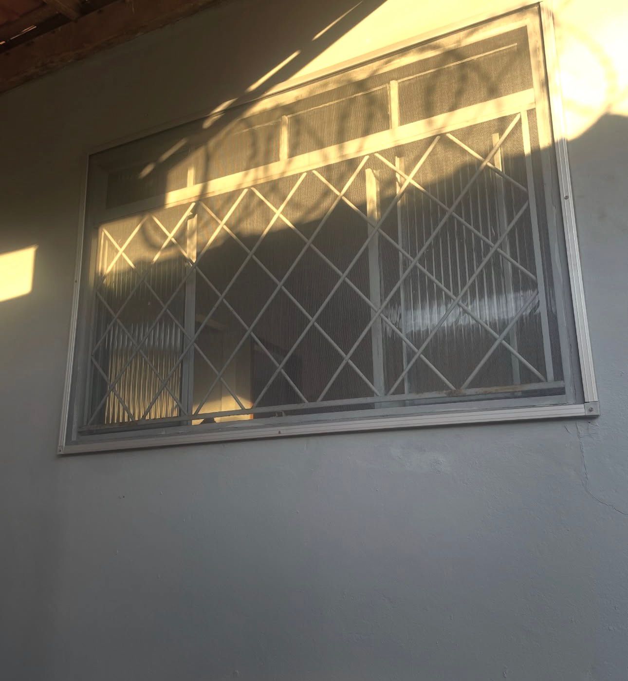 Rede de proteção em janela, detalhe da malha ao entardecer