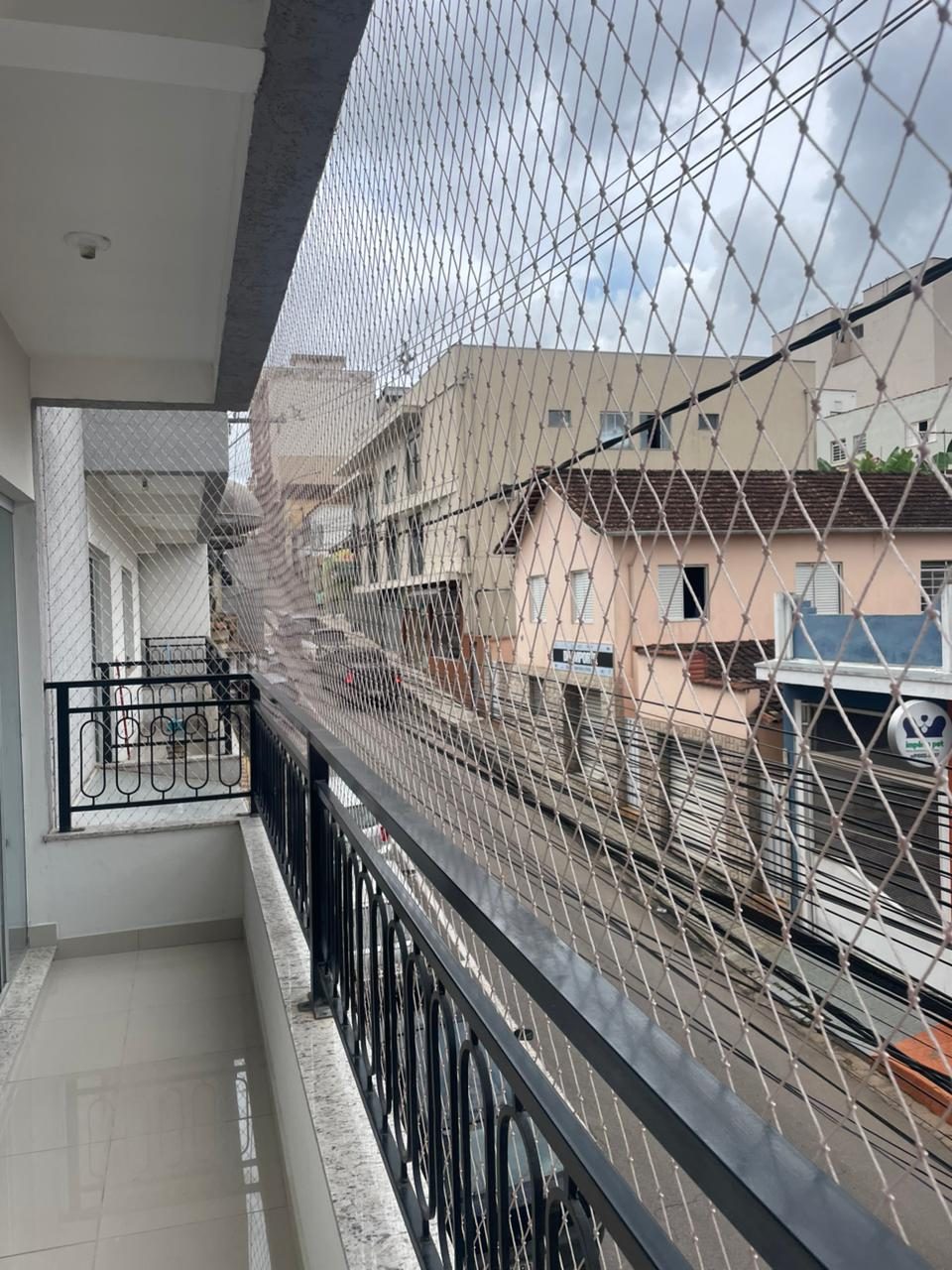 Rede de proteção em sacada de prédio com vista da cidade